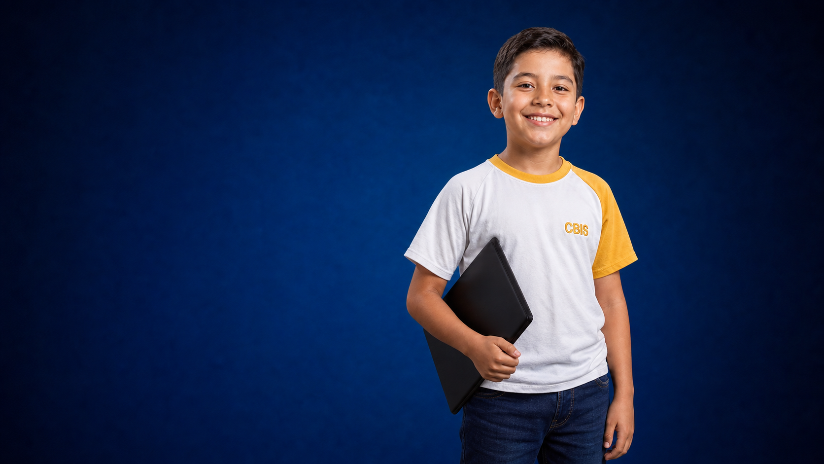 Estudiante CBIS con uniforme mostaza sostiene una computadora portátil